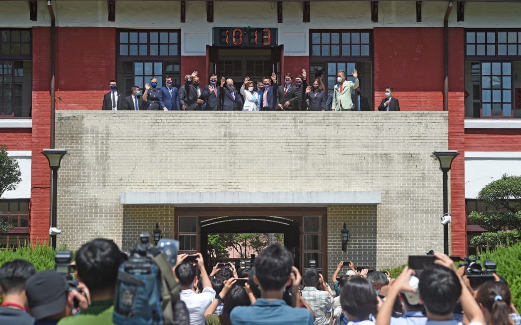 This picture taken by Taiwan’s Central News Agency (CNA) shows US House Speaker Nancy Pelosi and other officials waving to journalists at the Parliament in Taipei on August 3, 2022.
