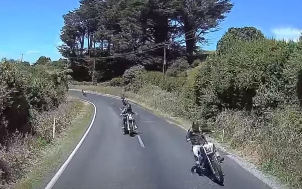 Dashcam footage shows a motorcycle driving over the centre line of a road in front of a truck.