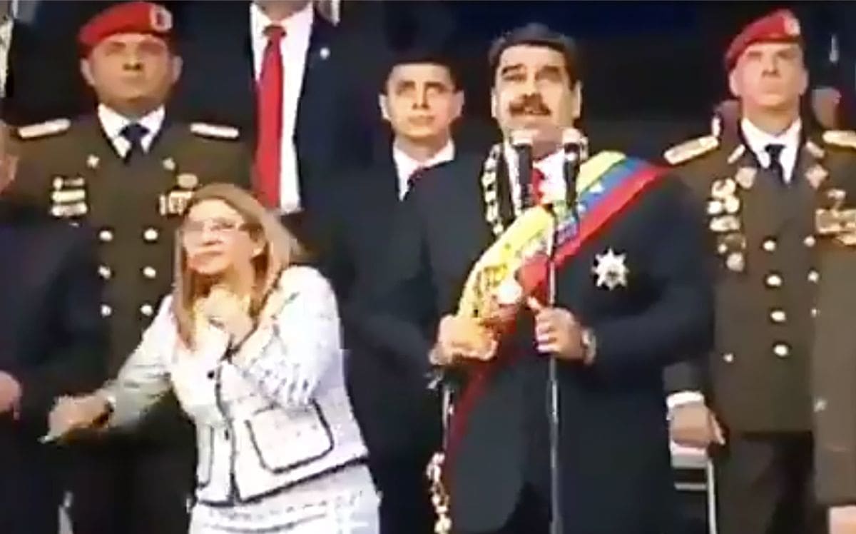 Venezuelan President Nicolas Maduro (C), his wife Cilia Flores (L) and military authorities reacting to a loud bang during a military ceremony.