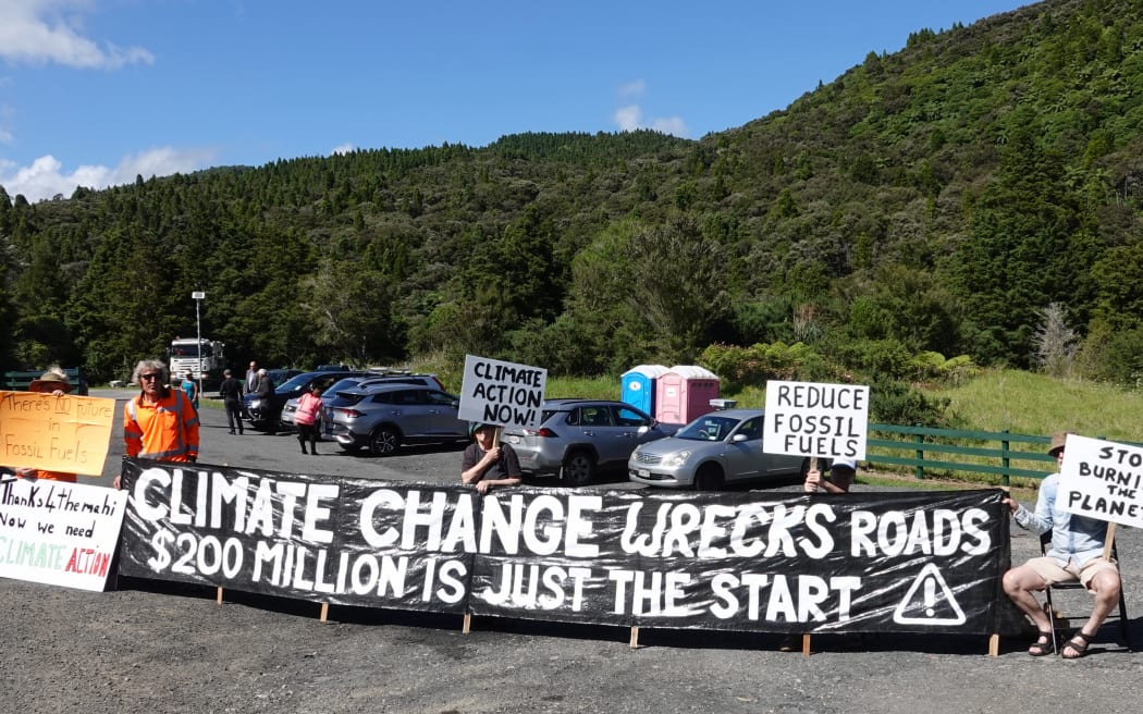 A small group of protesters call for action on climate change, which they say contributes to infrastructure-damaging storms.