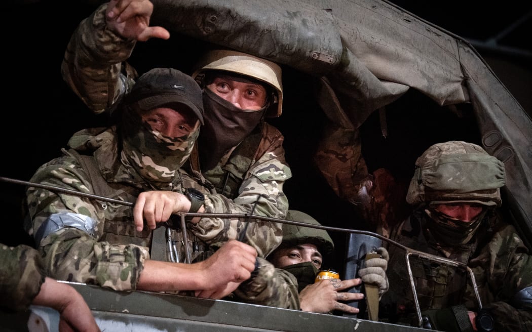 Members of Wagner group looks from a military vehicle in Rostov-on-Don late on June 24, 2023. Rebel mercenary leader Yevgeny Prigozhin who sent his fighters to topple the military leaders in Moscow will leave for Belarus and a criminal case against him will be dropped as part of a deal to avoid "bloodshed," the Kremlin said on June 24. (Photo by Roman ROMOKHOV / AFP)