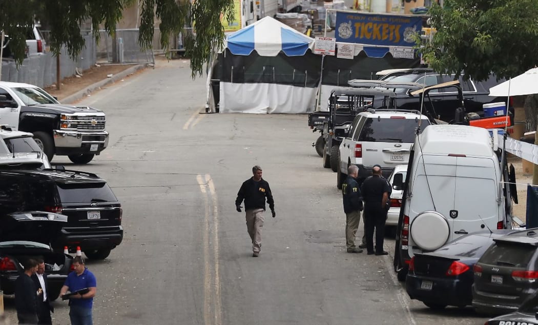 An FBI agent (C) walks near a ticketing booth for the Gilroy Garlic Festival two days after a mass shooting there.
