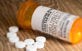 Tiltshift effect of prescription bottle for Oxycodone tablets and pills on wooden table for opioid epidemic illustration