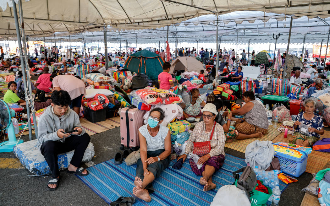 Evacuated Thai residents gather at a temporary shelter following clashes along the Thailand-Cambodia border in Buriram province on December 8, 2025. Thailand launched air strikes on its neighbour Cambodia on December 8, the Thai army said, with both sides trading blame for the latest eruption of fighting on their disputed border which killed a Thai soldier. (Photo by Sarot Meksophawannakul / THAI NEWS PIX / AFP)
