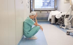 tired doctor alone in hallway