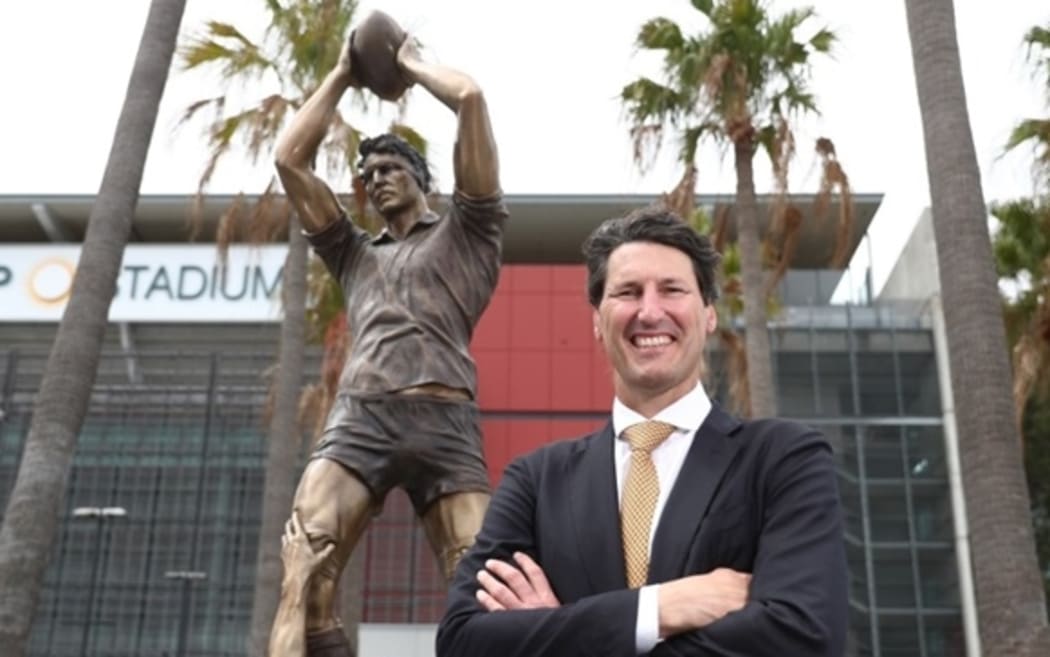 John Eales in front of the statue in his honour at Suncorp Stadium.