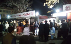Relatives of blast victims gather outside a hospital of the Italian aid organisation 'Emergency' in Kabul, following a blast at a meeting of top clerics in the Afghan capital.