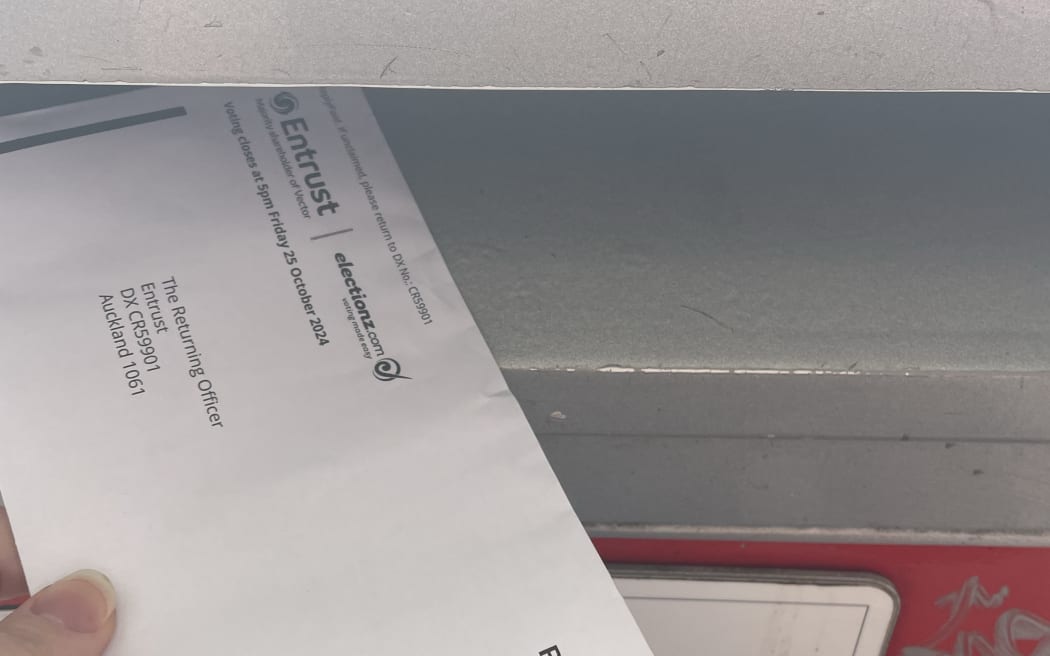An envelope going into a post office box, with an entrust logo on it.