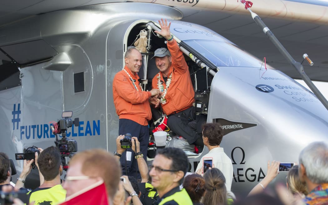 Solar Impulse 2 pilot Bertrand Piccard(L) and pilot Andre Borschberg, wave after Borschberg landed at Kalaeloa Airport, Hawaii.