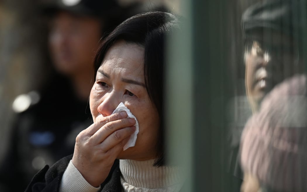 A relative of a passenger on board the missing Malaysia Airlines flight MH370 reacts during a gathering outside the Malaysian embassy in Beijing on 8 March, 2024, on the 10th anniversary of the flight’s disappearance.