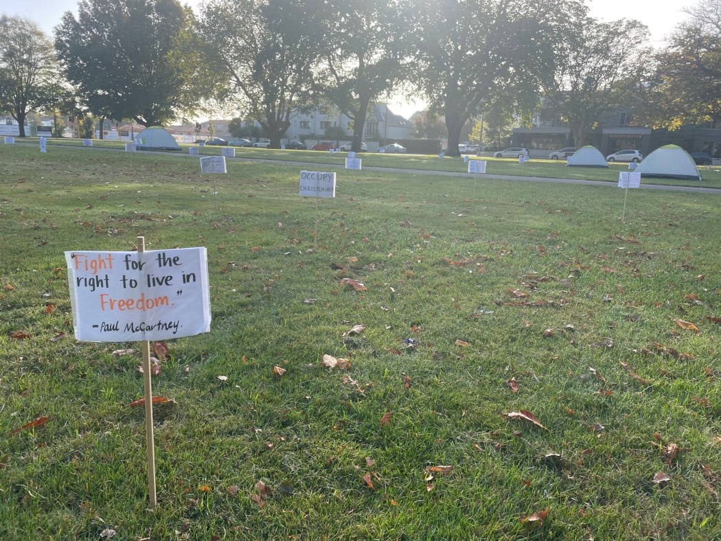 A protest camp in Christchurch's Latimer Square, where signs and tents have been hammered into the grass.