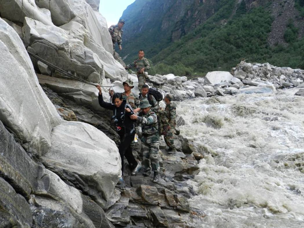 File photo: Indian defence personnel assist a stranded civilian to safety after flooding in northern Uttarakhand state in 2013.