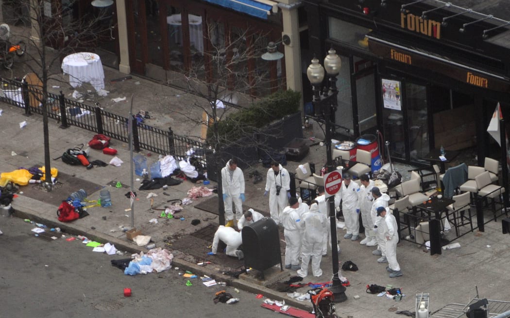 Investigators in white jumpsuits work the crime scene on Boylston Street following the bomb attack at the Boston Marathon April 16, 2013.