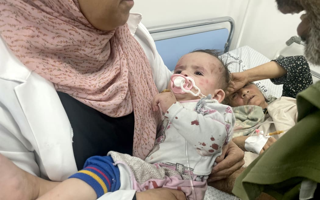A doctor carries an infant injured after Israeli bombardment, at the Kuwaiti hospital in Rafah in the southern Gaza Strip on October 21, 2023 amid the ongoing battles between Israel and the Palestinian group Hamas.