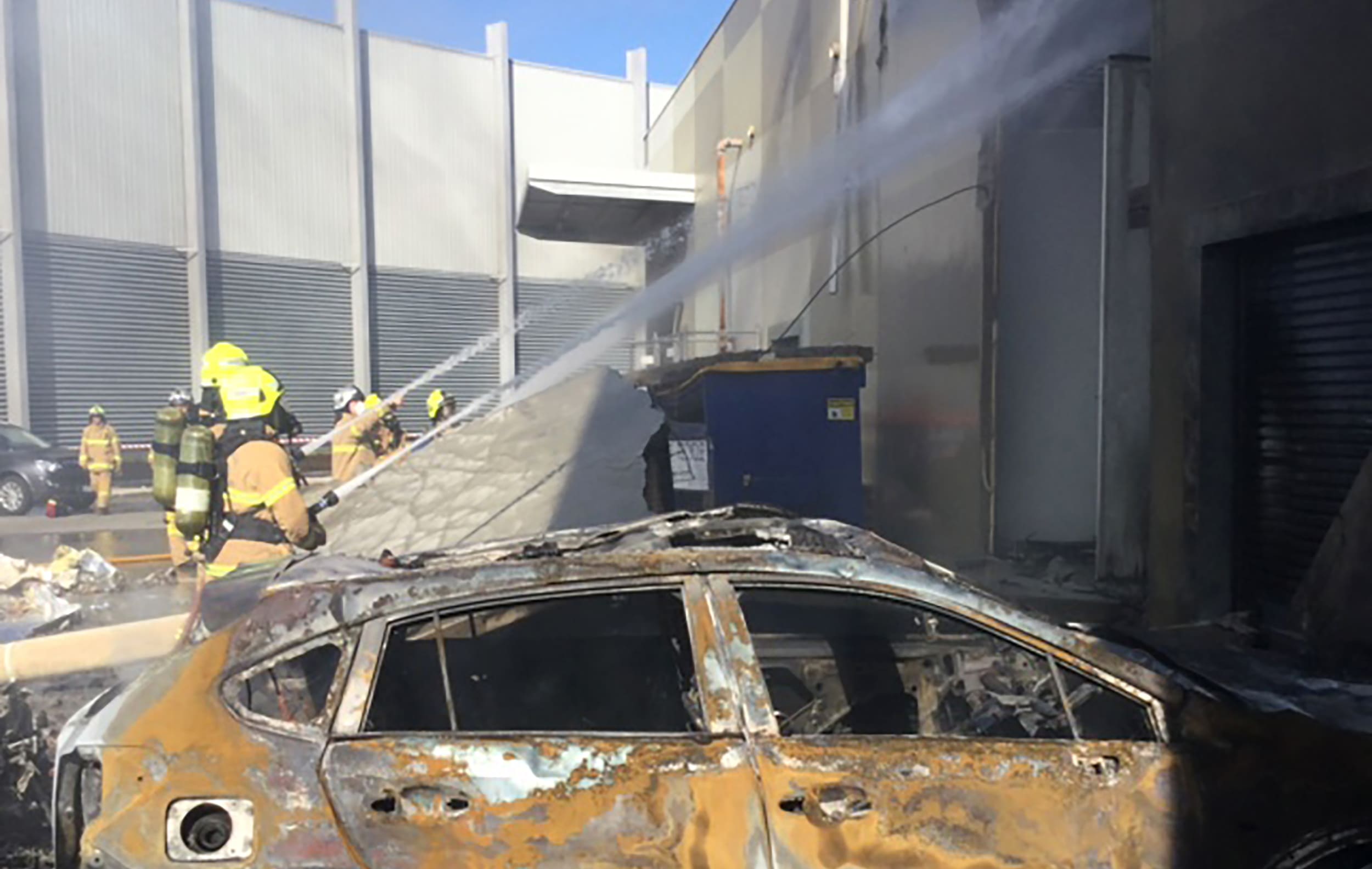 Crews putt out a blaze from a light aircraft which exploded as it smashed into a shopping centre near Melbourne.
