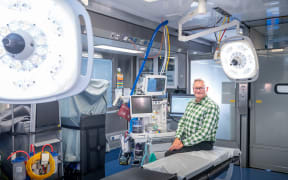 Operating theatre inside truck with man sitting on operating table