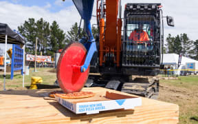 Winner Steven George slicing a pizza using his excavator digger