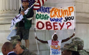 Protesters yell at members of the National Guard outside Union Station on August 19, 2025 in Washington, DC. An increased presence of law enforcement has been seen throughout the nation's capital since US President Donald Trump announced plans to deploy federal officers and the US National Guard.   Alex Wong/Getty Images/AFP (Photo by ALEX WONG / GETTY IMAGES NORTH AMERICA / Getty Images via AFP)