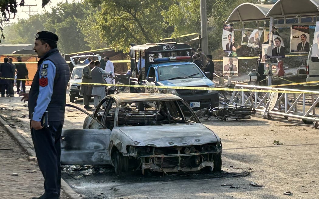 Policemen examine damaged vehicles after a suicide blast outside the district court in Islamabad on 11 November, 2025.
