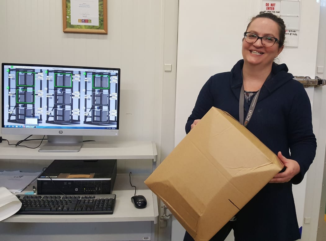Lou Sherman in front of the WHITE room with a box that has failed during testing.Sensors inside the room show scientists what is happening as the experiment progresses.