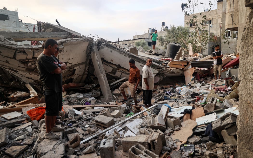Palestinians check the rubble of a building destroyed by an Israeli strike in the Nuseirat refugee camp in the central Gaza Strip on September 28, 2025. Over nearly two years, Israeli military operations in Gaza have killed at least 65,549 Palestinians, mostly civilians, according to the health ministry in Hamas-run Gaza, figures the UN considers reliable. (Photo by Eyad BABA / AFP)