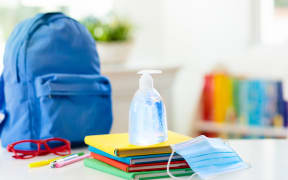 Backpack of school child with face mask and sanitizer. Student safety after coronavirus pandemic. Virus and disease prevention for kids. Back to school and kindergarten after covid-19 outbreak.