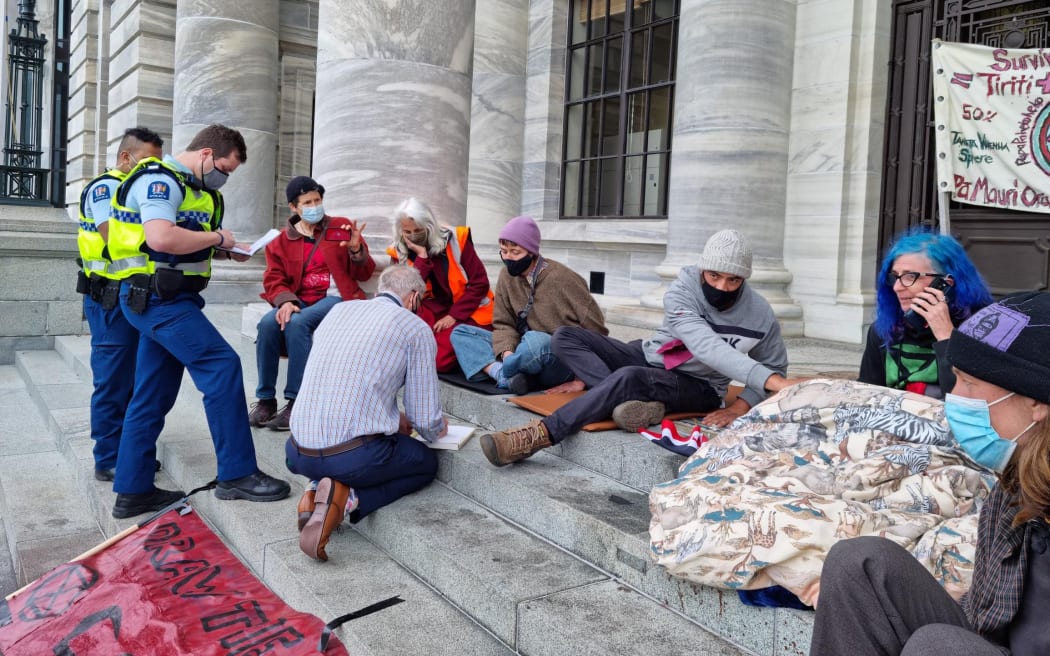 Climate protesters have glued their hands to the steps in front of Parliament.