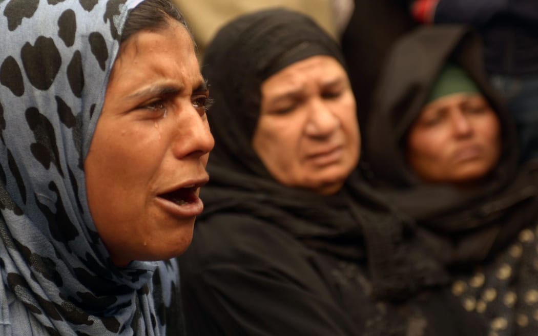 A relative of one of the accused cries outside the court.