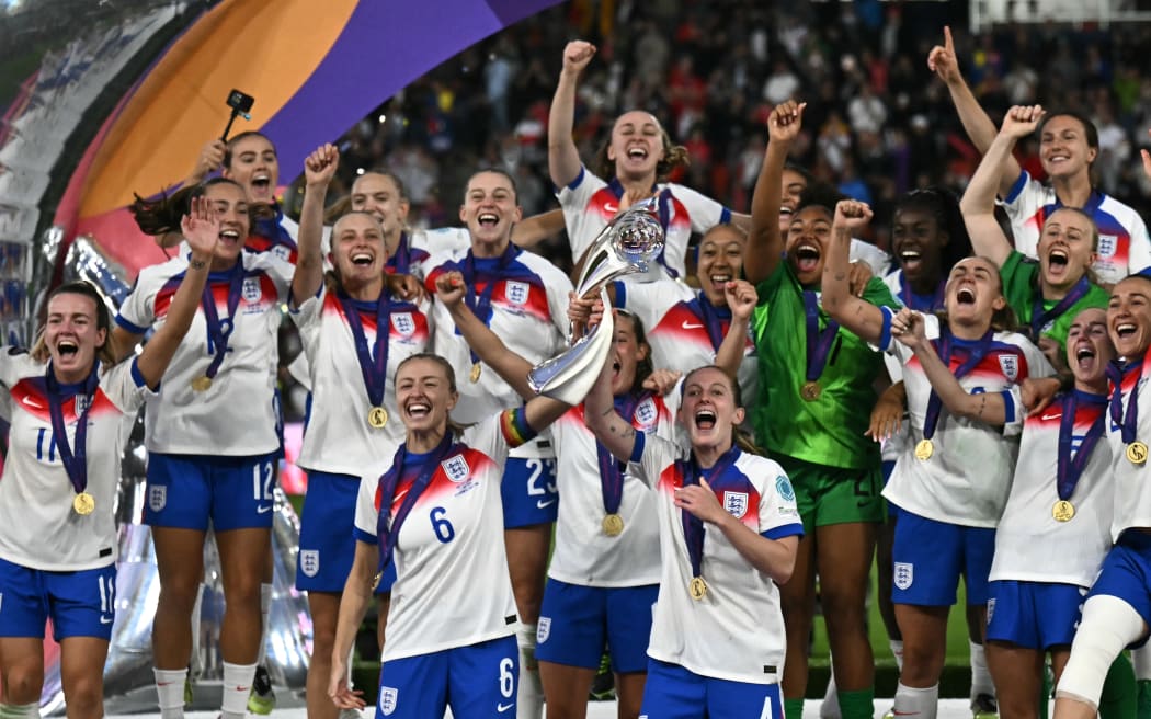 England's defender #06 Leah Williamson (CL) and England's midfielder #04 Keira Walsh (CR) lift the trophy as England celebrate winning the UEFA Women's Euro 2025 final football match between England and Spain at the St.