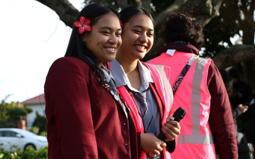 Theresa Viane (R) and another student leader smile at the crowd of students gathered.