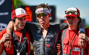 Hayden Wilde is helped off the finish line after finishing 2nd in the Ironman 70.3 World Championship Pro Men race held in Taupo, New Zealand,  2024.