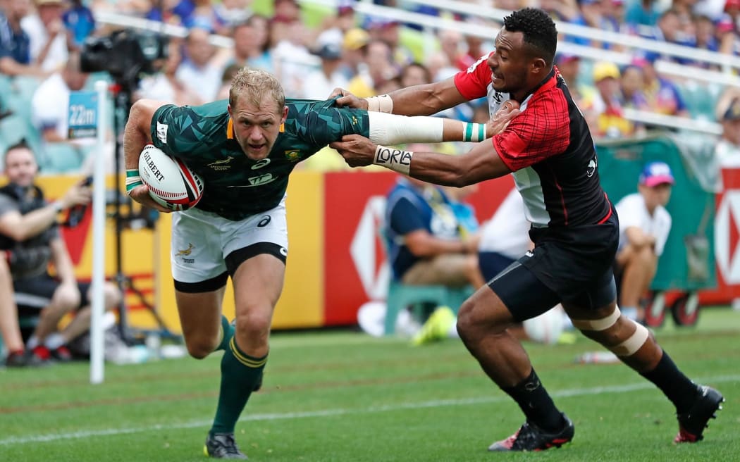 South Africa captain Philip Snyman fends off the Papua New Guinea defence during their opening pool match in Sydney.