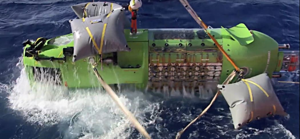 A submersible rises to the ocean surface after a dive.