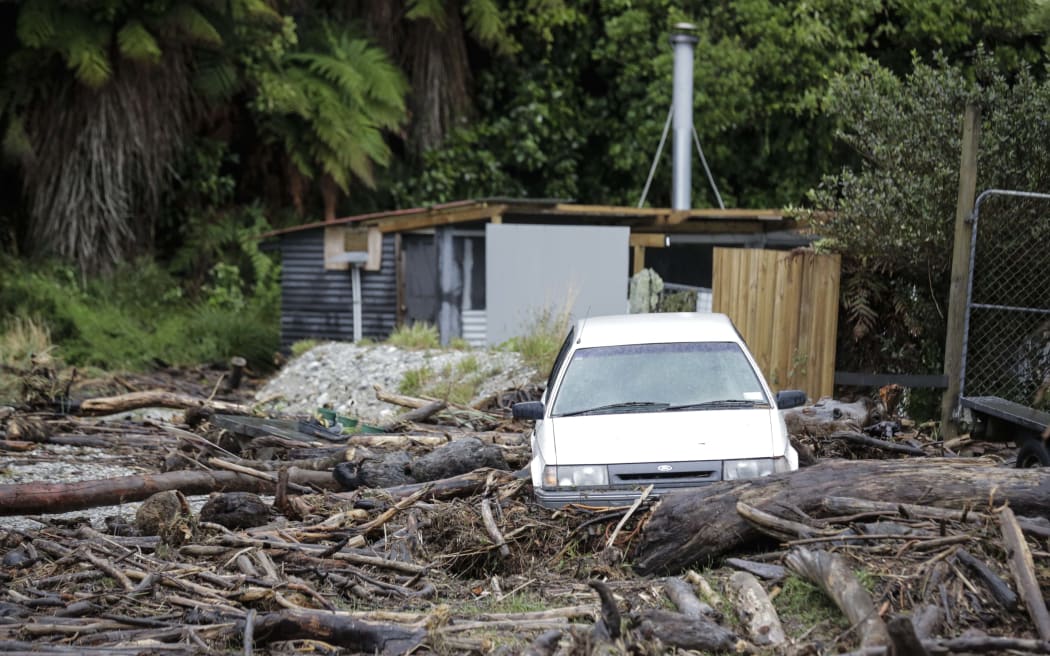 Signifigant damage to the tiny sea side settlement of Fox River. A vechile sits on the yard full of wood debris.
