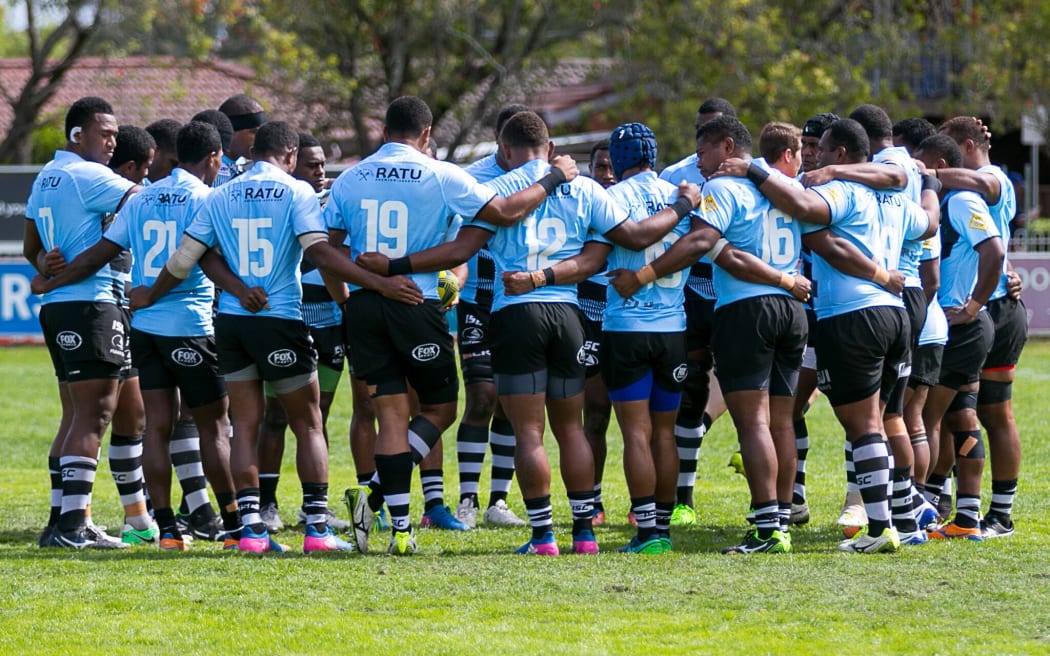 The Fijian Drua huddle together.