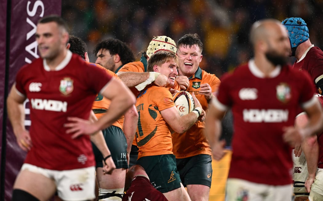 Tate McDermott of Australia celebrates with teammates after scoring a try against the British and Irish Lions, 2025.