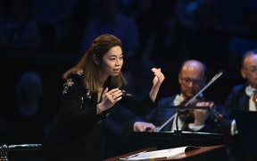 Conductor Elim Chan coaxes the orchestra from the podium.