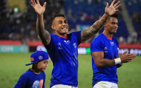 Tusi Pisi (c) waves to the crowd alongside his son Theron.