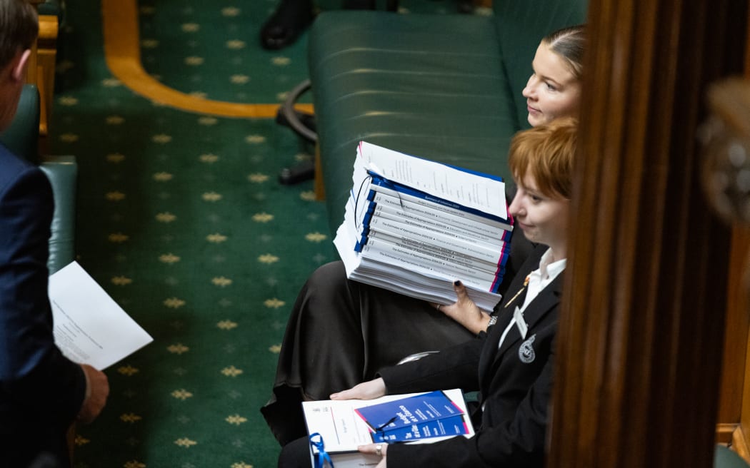 Chamber and House staffers wait with copies of budget documents to Table once they are introduced.