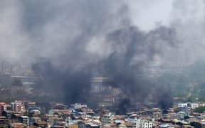 Smoke rises over Tamwe township in Yangon on March 27, 2021, as security forces continue their crackdown on protests against the military coup. (Photo by STR / AFP)