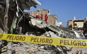 Peruvian rescuers work at the Tarqui neigborhood in Manta, Ecuador.