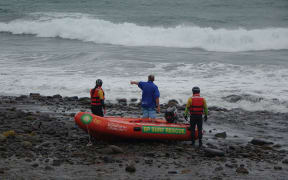 Surf lifesavers prepare to head out from Back Beach to search for man missing after his dinghy capsized.