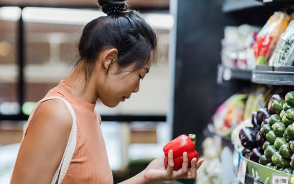 a woman holding a capsicum