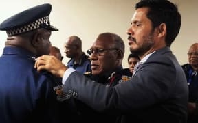 Chief Supritendent  Joe Poma promoted to assistant police commissioner by PNG's Police Minister Bryan Kramer. Former Police Commissioner Gary Baki (middle) observes.