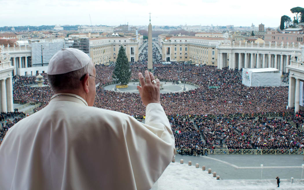 Pope Francis gives his blessing from a balcony at the Vatican.