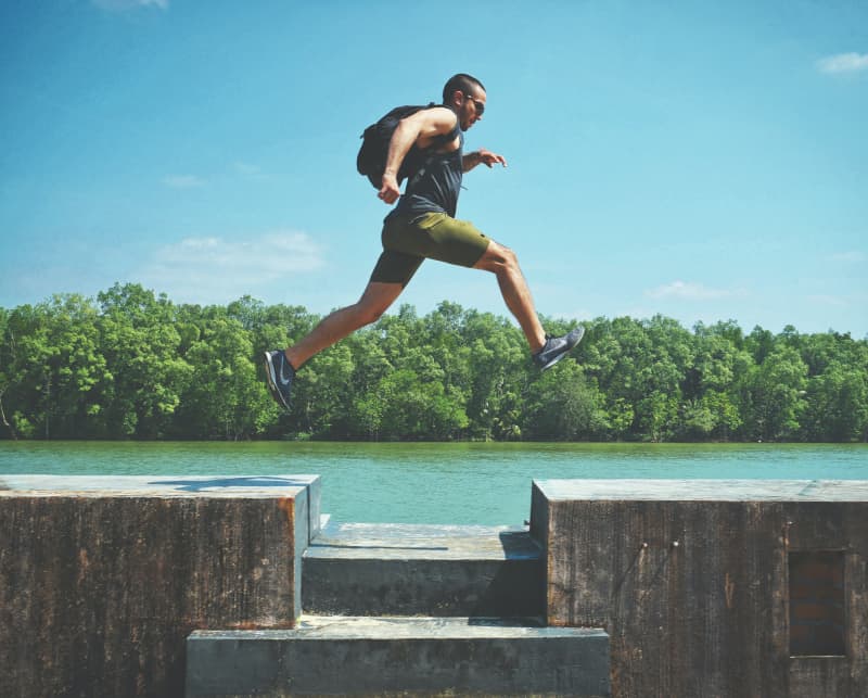 Man leaping over a gap in a walkway