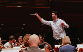 NZSO Conducting Fellow Reuben Brown conducts the orchestra at the Second Session, 2023