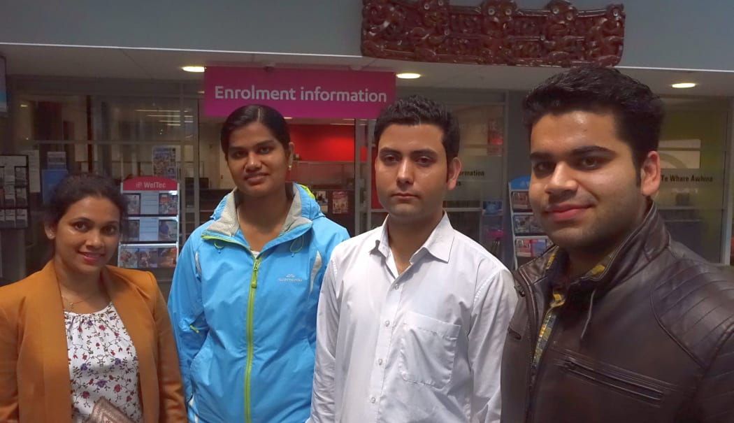Four students stand next to each other