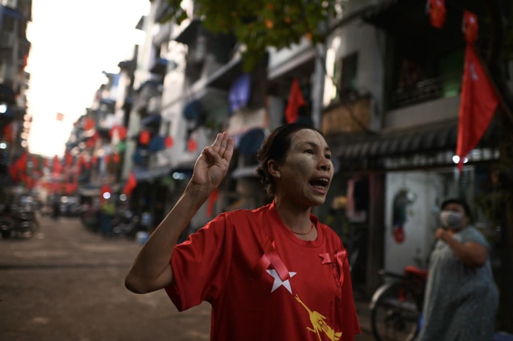 A woman poses for a photo as she holds up the three-finger salute and calls for the release of detained civilian leader Aung San Suu Kyi in Yangon on February 5, 2021,