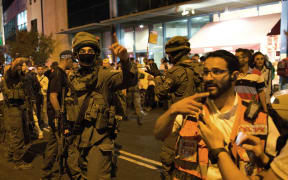 Israeli security forces, police and a medical team arrive at the site where a knife-wielding man stabbed and moderately wounded a woman near Jerusalem's central bus station on October 14, 2015.